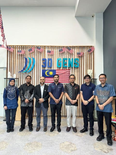 Delegation members stand together for a photo in front of the 3D Gens sign