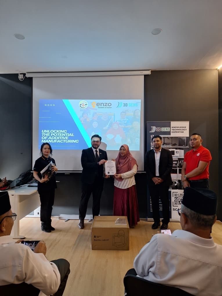 A female participant receives her Enzo Training Academy certificate from 3D Gens trainers at the SDEC 3D printing programme
